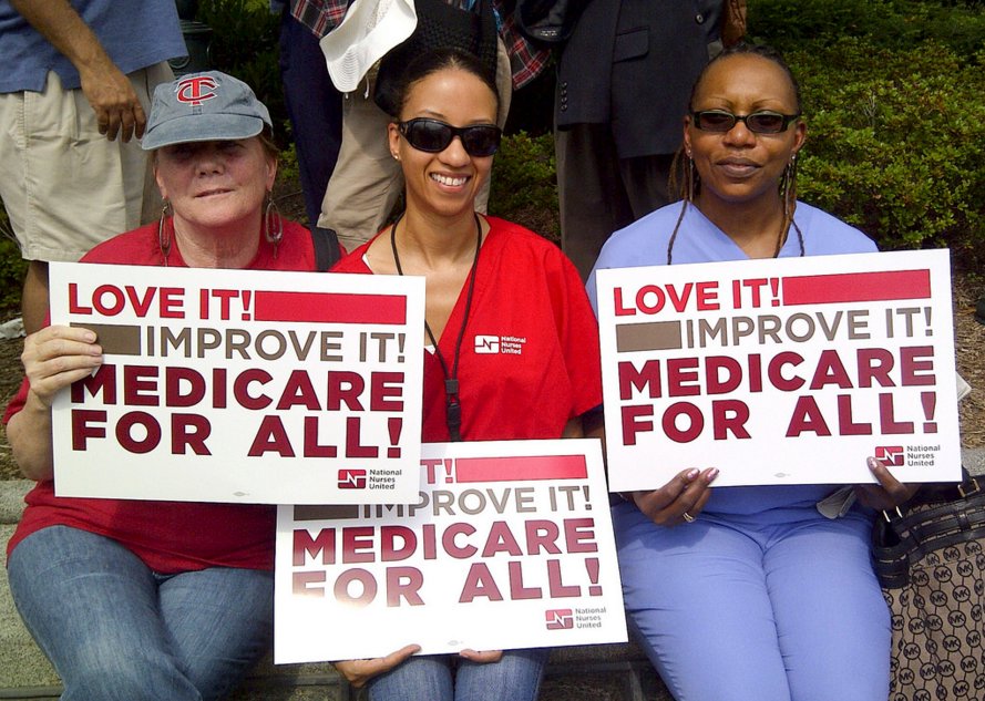 Three women holding up posters that say 