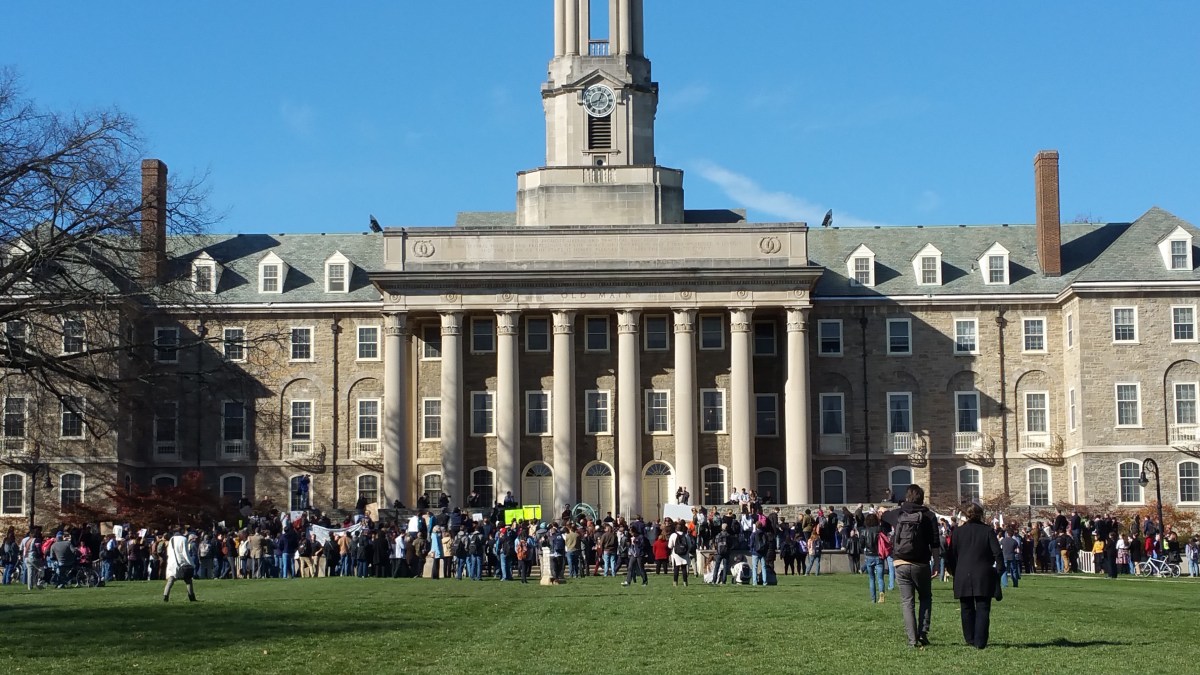 picture of PSU's Old Main Building surrounded by students, faculty, staff, and community members at the "#NotMyPresident Walk-Out/Love Trumps Hate" Rally