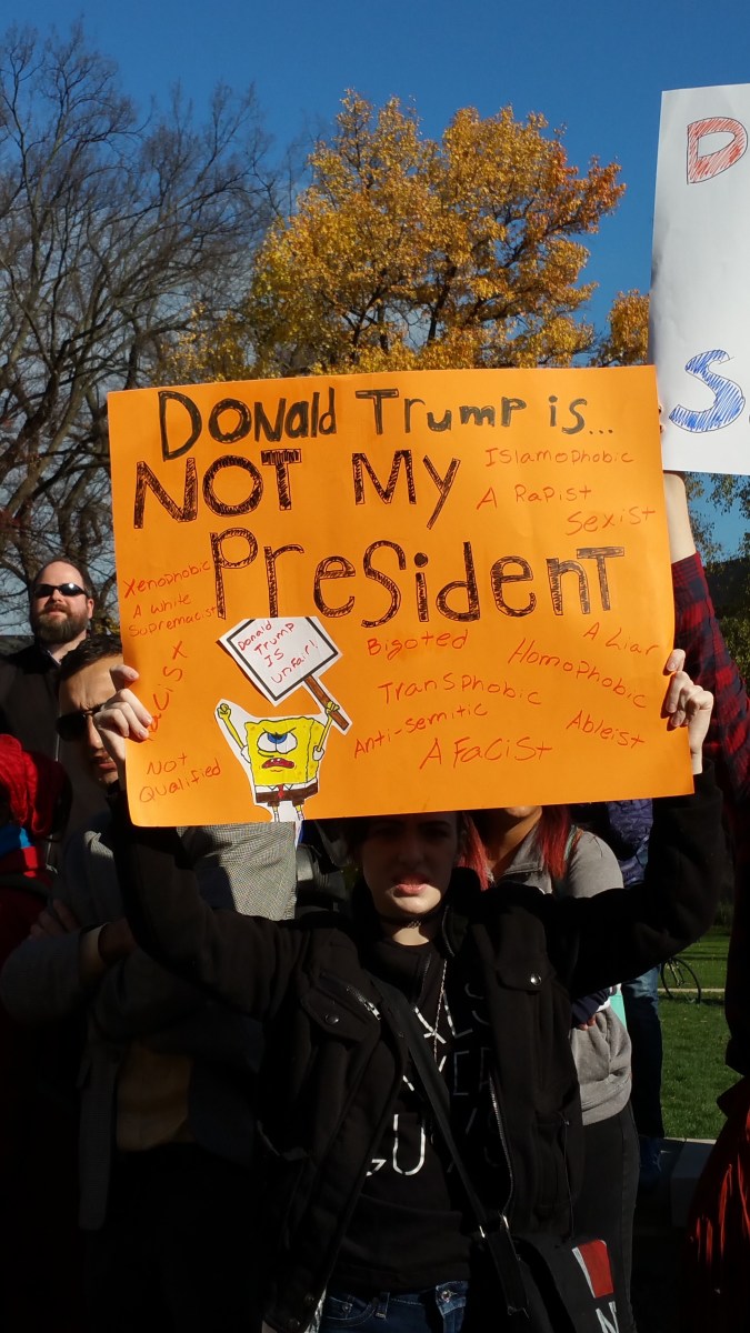 sign saying Donald Trump is NOT My President with Sponge Bob saying, "Trump is unfair" and listing the "unfair" things he has done or said. Racism. Homophobia, Alleged rapist. Bigotry, Transphobia. White Supremacy. Etc.
