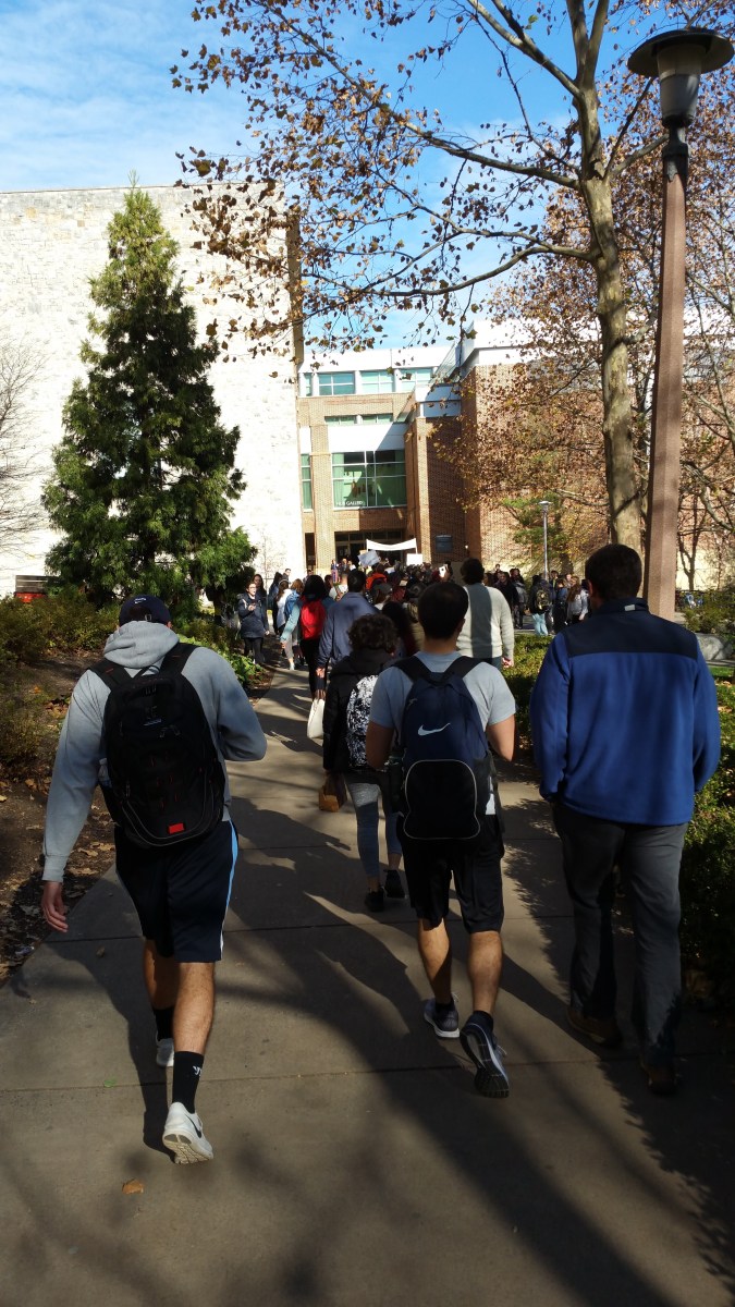 picture of people moving from the outdoor rally into the HUB for the second part of the program.