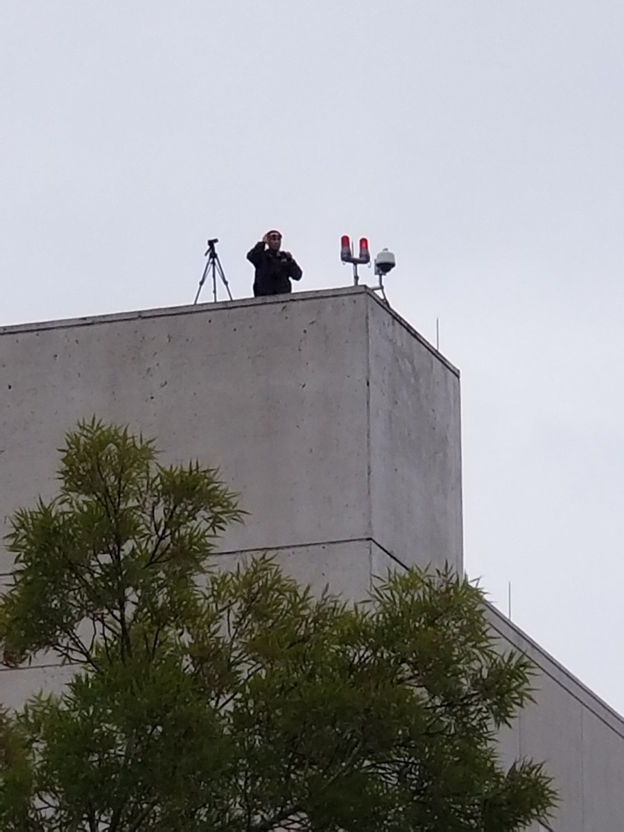 picture of a federal agent surveilling the crowd attendees.