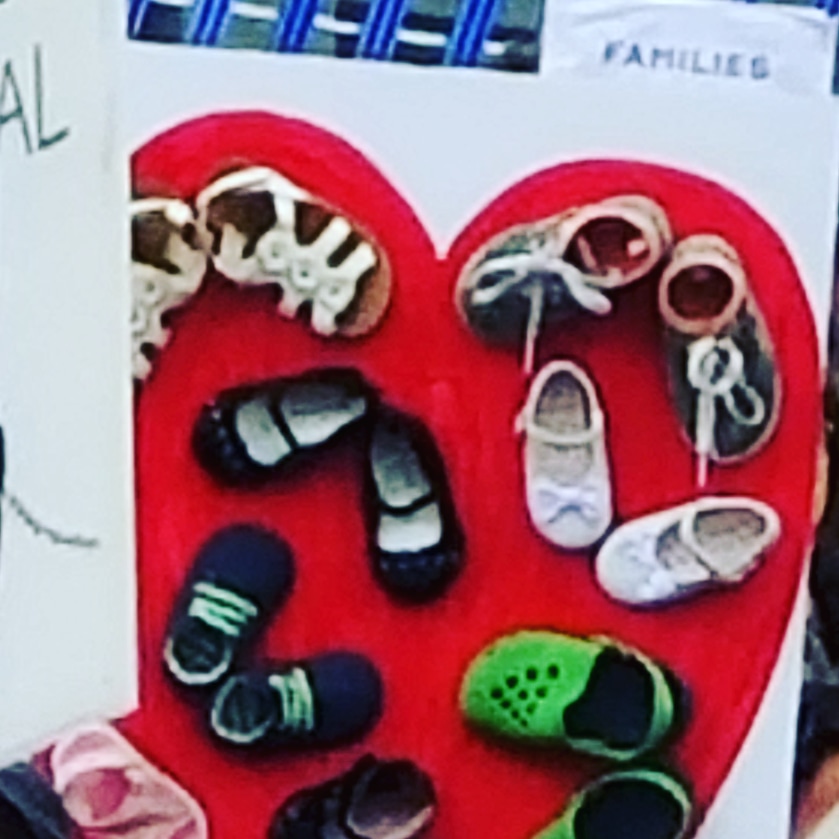picture of a heart-shaped sign decoration with babies' and toddlers' shoes